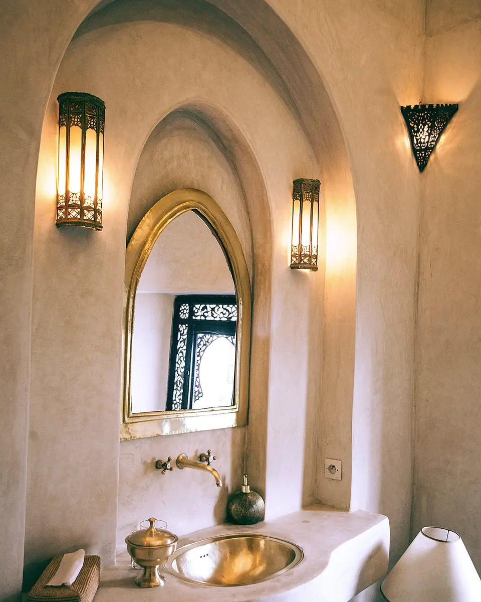 Arched niche, brass basin and pierced metal wall lights